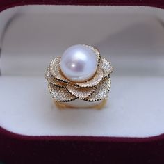 This elegant ring features a stunning 11-12mm white freshwater pearl accented by a brilliant 11-12mm Miya zirconia flower. The open closure design adds a modern touch to this timeless piece. Expertly crafted, this ring is a must-have for any pearl lover's collection. Material: 925 Sterling Silver, 4A freshwater pearl, and cubic zirconia Flexible size with open closure Elegant Cubic Zirconia Flower Ring For Formal Events, Elegant Cubic Zirconia Flower Ring, Elegant White Gold Flower Ring With Cubic Zirconia, Elegant Flower Ring With Diamond Accents For Gift, Elegant Flower Ring With Diamond Accents As Gift, Elegant White Flower Ring With Diamond Accents, Elegant White Flower Ring, Elegant Rose Gold Cubic Zirconia Flower Ring, Elegant White Flower Shaped Ring