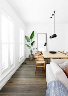 a living room filled with furniture and a wooden table in front of a white wall