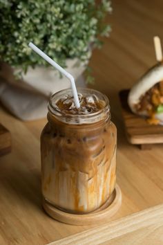 there is a drink in a mason jar on the table next to a hot dog