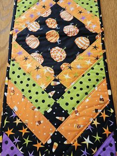 a quilted table runner with halloween decorations and stars on the bottom, along with polka dots