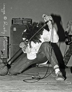 a man with dreadlocks on his head sitting in front of an amp and guitar