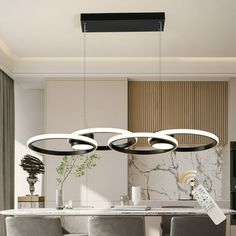 a modern kitchen with marble counter tops and grey chairs, along with an oval chandelier that hangs from the ceiling