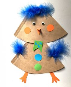 a paper plate christmas tree with blue feathers on it and an orange piece of cardboard