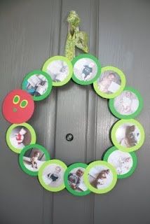 a green wreath with pictures hanging on it