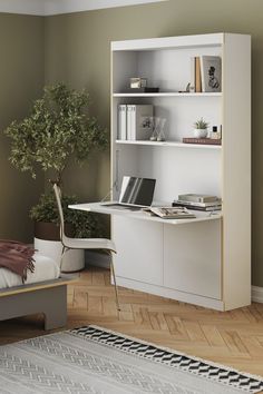 a bedroom with a bed, desk and bookshelf next to a plant in the corner