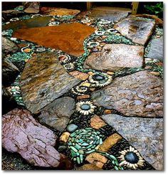 a rock garden with stones and flowers on it