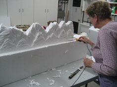 a woman is working on a sculpture in the process of making it look like mountains