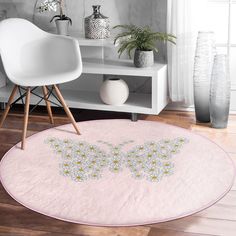 a white chair sitting on top of a hard wood floor next to a pink rug