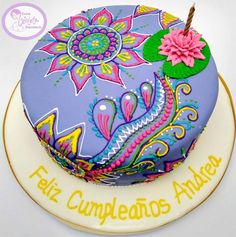 there is a cake that has been decorated with flowers and leaves on the top it says feliz cumpleatos anualis