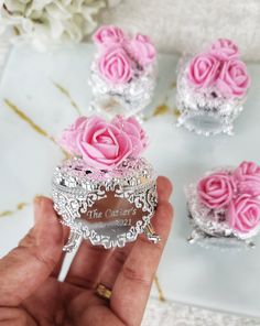 pink roses are placed on top of silver containers