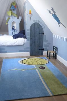 a child's bedroom decorated in blue and white with a castle rug on the floor