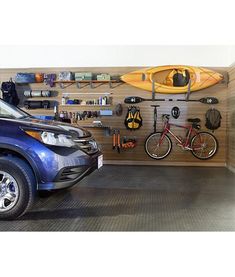 a car is parked in front of a wall mounted kayak rack