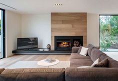 a living room filled with furniture and a fire place next to a dining table on top of a hard wood floor