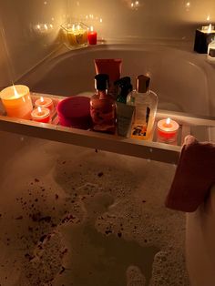 candles and bottles in a bathtub filled with soap