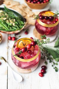 two glasses filled with cranberry orange sangria and garnished with greenery