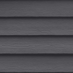 the side of a house with dark gray siding and wood slats on it's sides