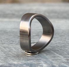 a ring sitting on top of a wooden table next to a stone wall with a small hole in the middle