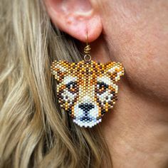 a close up of a person wearing some kind of earring with a tiger design on it