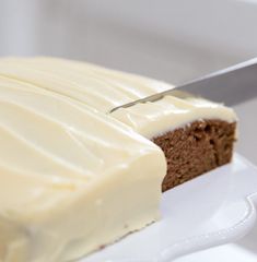 a piece of cake is being cut with a knife