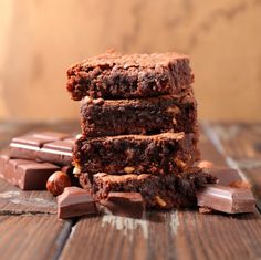 three brownies stacked on top of each other with chocolate chips and nuts around them