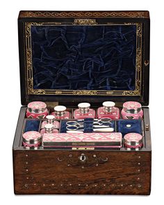 an antique wooden box filled with pink and blue items