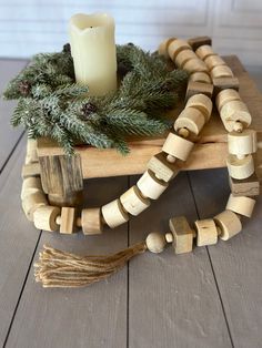 a wooden bead necklace with a candle on it and pine cones in the center