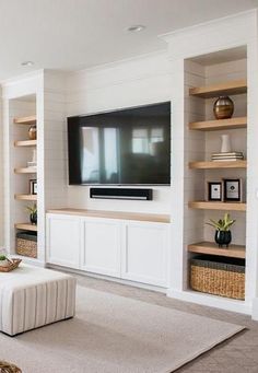 a living room filled with furniture and a flat screen tv mounted on the wall above it