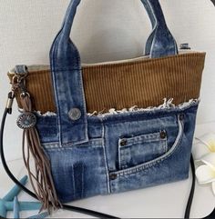 a handbag made out of old jeans with fringes on the handles and sides