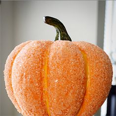 an orange pumpkin sitting on top of a metal stand