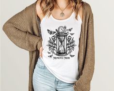 This unique memento mori tank top is a perfect addition to any dark cottagecore, dark academia aesthetic. The Next Level 1533 Tank Top is our most popular and comfortable tank. All colors are 60% combed ringspun cotton and 40% polyester. This is an extra light, breathable fabric perfect for warm summer days or serious sessions at the gym! Please see size chart in listing images * Sizing is SLIM FIT and considered to run small. * Unsure about sizing? Take out your favorite fitting top and measure Goth Tank Top, Gothic Moth, Moth Shirt, Homebody Shirt, Witchy Clothing, Lunar Moth, Cottagecore Shirt, Librarian Shirt, Dark Cottagecore