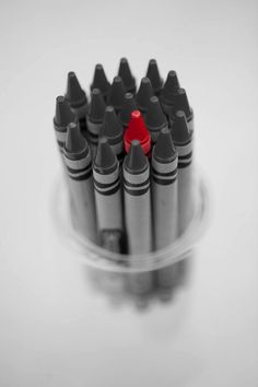 a group of black and red crayons sitting on top of a white table