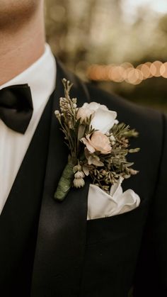 a man in a tuxedo wearing a boutonniere with flowers on it