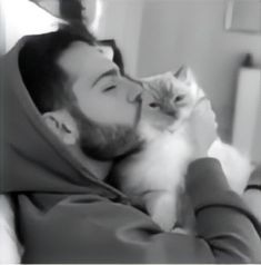 a man holding a white cat in his arms