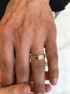 a man's hand with a gold ring on it and another person's finger