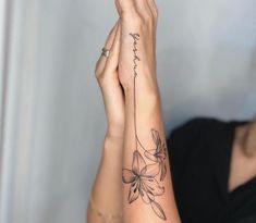 a woman's arm with a flower tattoo on the left side of her arm