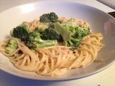 a white bowl filled with pasta and broccoli