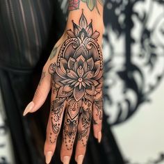 a woman's hand with a tattoo on it and a flower in the middle