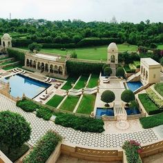 an aerial view of a garden and pool in the middle of a large yard with trees