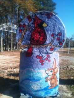 a blue and red trash can with a bird on it