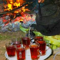 tea being poured into glasses on a tray