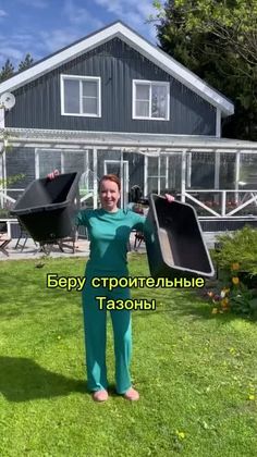 a woman standing in front of a house holding up two large black objects with the words happy birthday