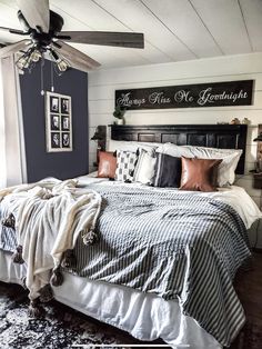 a bedroom with a bed, ceiling fan and two pictures on the wall above it