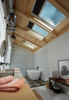 a bathroom with a skylight above the bathtub and sink area is shown in this image