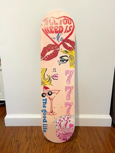 a pink skateboard sitting on top of a wooden floor next to a white wall