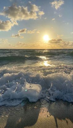 the sun is setting over an ocean with waves