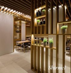 the interior of a restaurant with wooden shelves and plants in vases on the counter