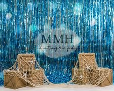 two wooden chairs sitting next to each other in front of a blue curtain with the words mmh on it