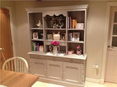 a white bookcase with flowers and books on it