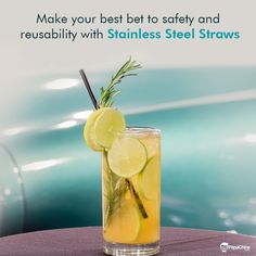 a tall glass filled with lemonade and limes on top of a table next to an old car