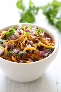 a white bowl filled with chili and cheese